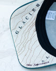 brim view of the final switchback trucker hat featuring artist Katie Jeanne Reim's Glacier Grinnell print