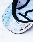 brim view of the final switchback 5-panel trail hat featuring artist Katie Jeanne Reim's Glacier Two Medicine print
