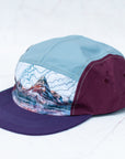 angle view of the final switchback 5-panel trail hat featuring artist Katie Jeanne Reim's Glacier Two Medicine print