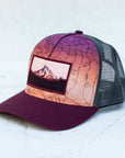 angle view of the final switchback trucker hat featuring artist Katie Jeanne Reim's mount hood sunset print