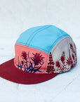 angle view of the final switchback 5-panel trail hat featuring artist Katie Jeanne Reim's Paintbrush print
