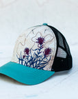 angle view of the final switchback trucker hat featuring artist Katie Jeanne Reim's paintbrush print