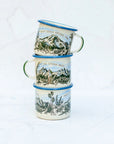 Three stacked final switchback fireproof enamel mugs featuring artist Katie Jeanne Reim's Tatoosh Range print