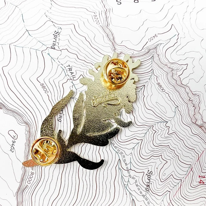 the back  of the final switchback alpine lupine enamel pin created by artist Katie Jeanne Reim