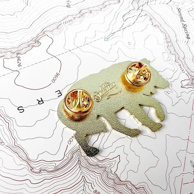 the back of the final switchback grey wolf enamel pin created by artist Katie Jeanne Reim