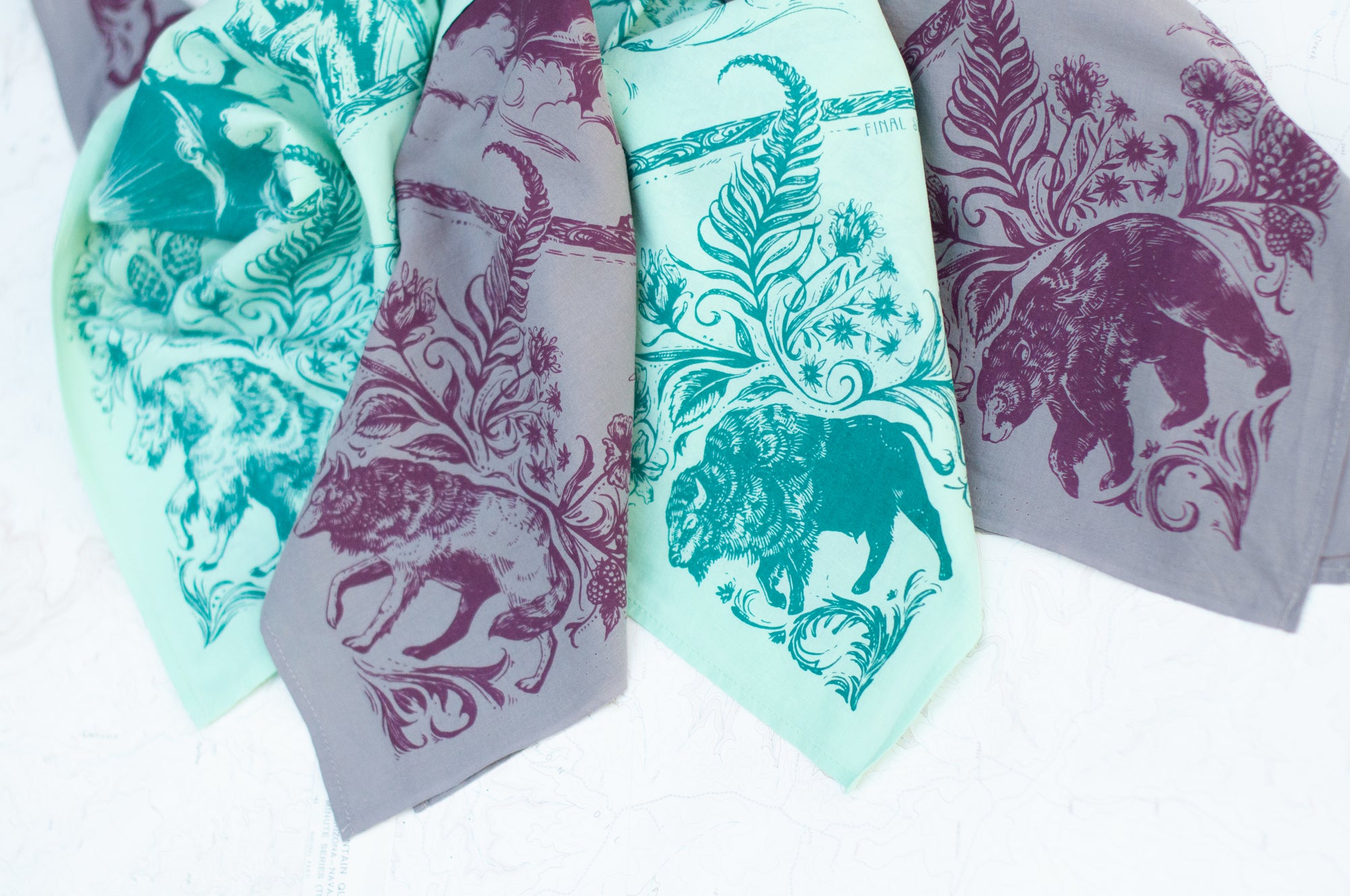 close-up of two final switchback cotton bandanas in backcountry mint and purple featuring artist Katie Jeanne Reim&#39;s prints