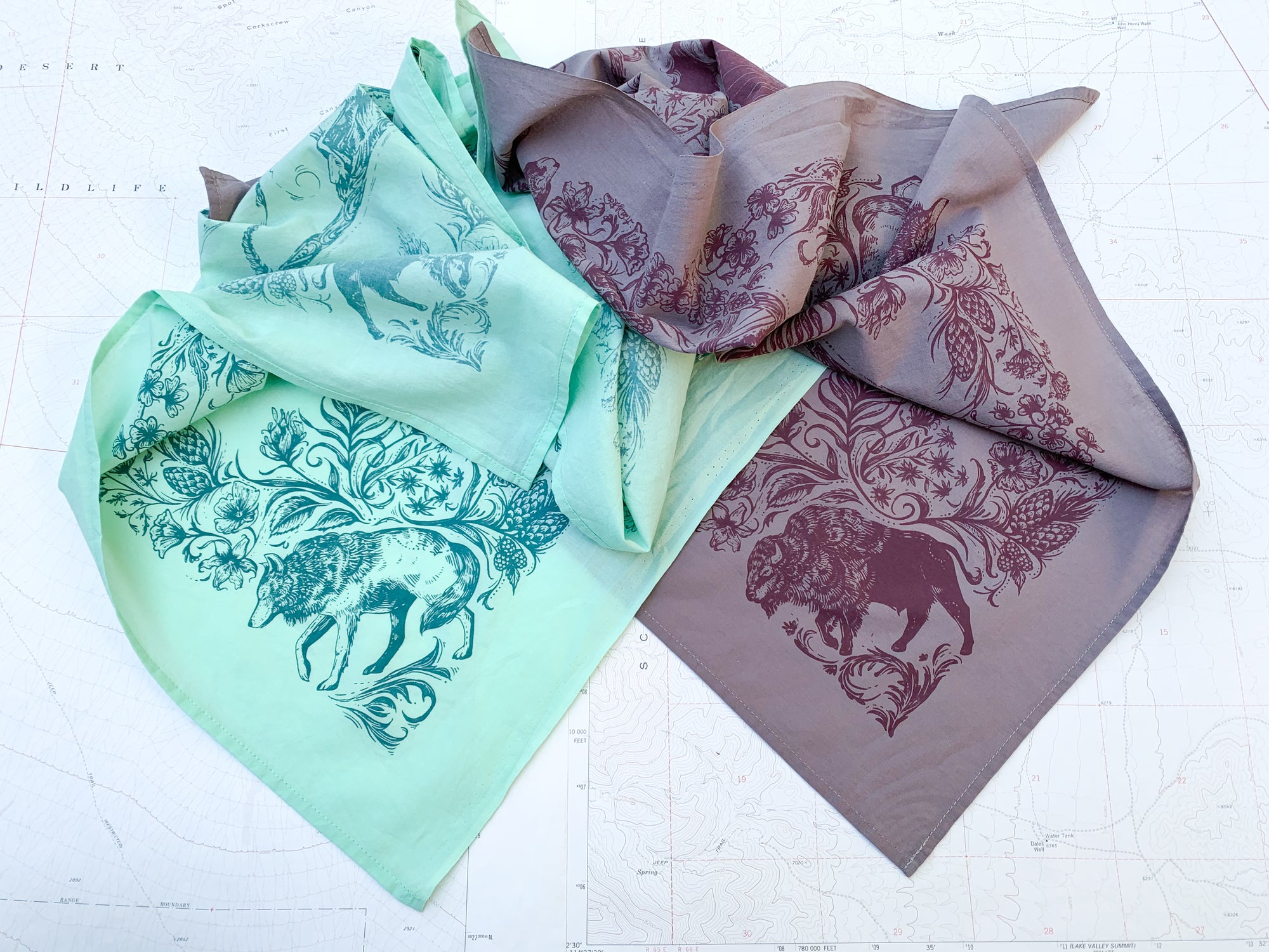 two final switchback cotton bandanas in backcountry mint and purple featuring artist Katie Jeanne Reim&#39;s prints