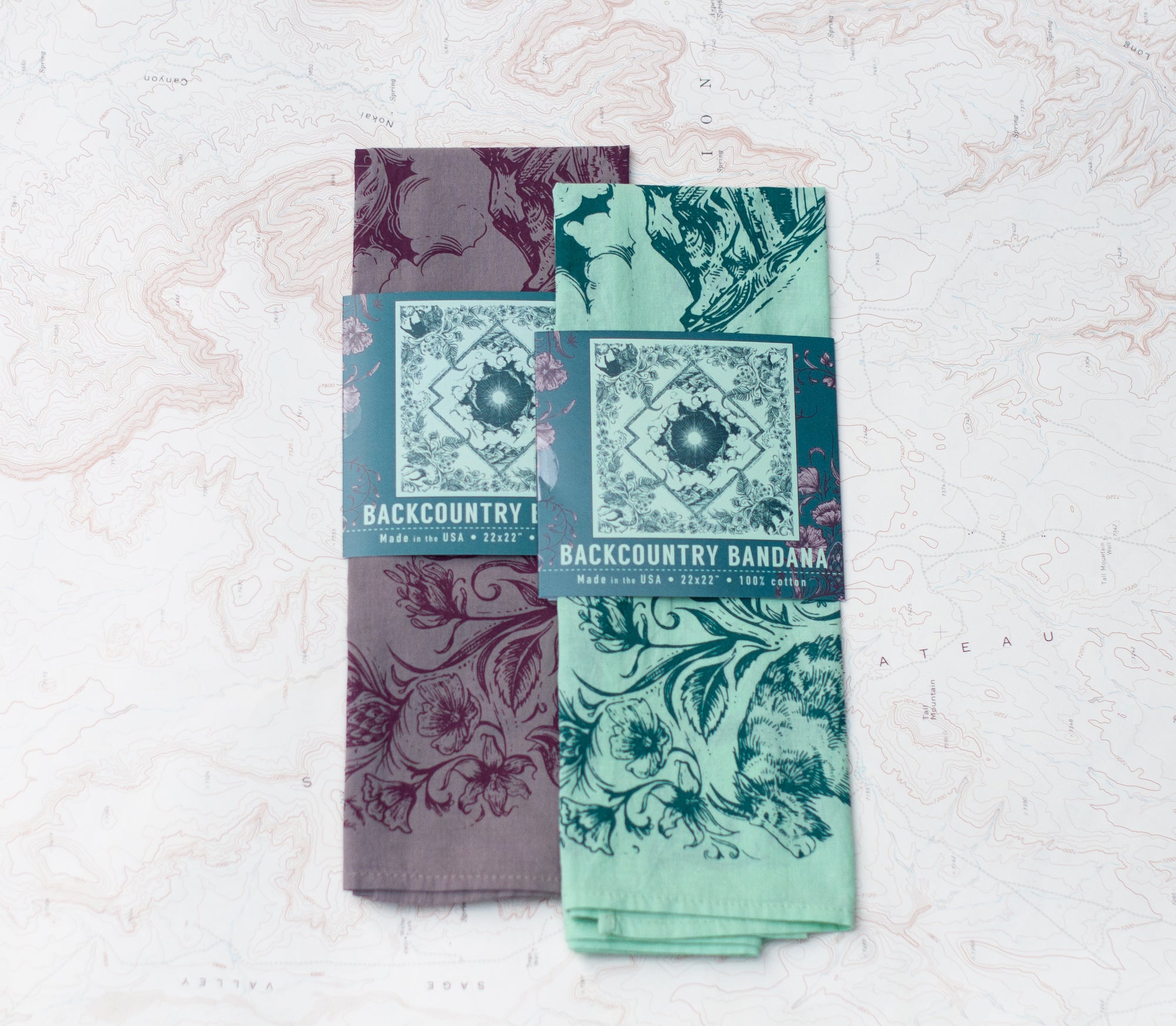 two final switchback cotton bandanas in backcountry mint and purple featuring artist Katie Jeanne Reim&#39;s prints