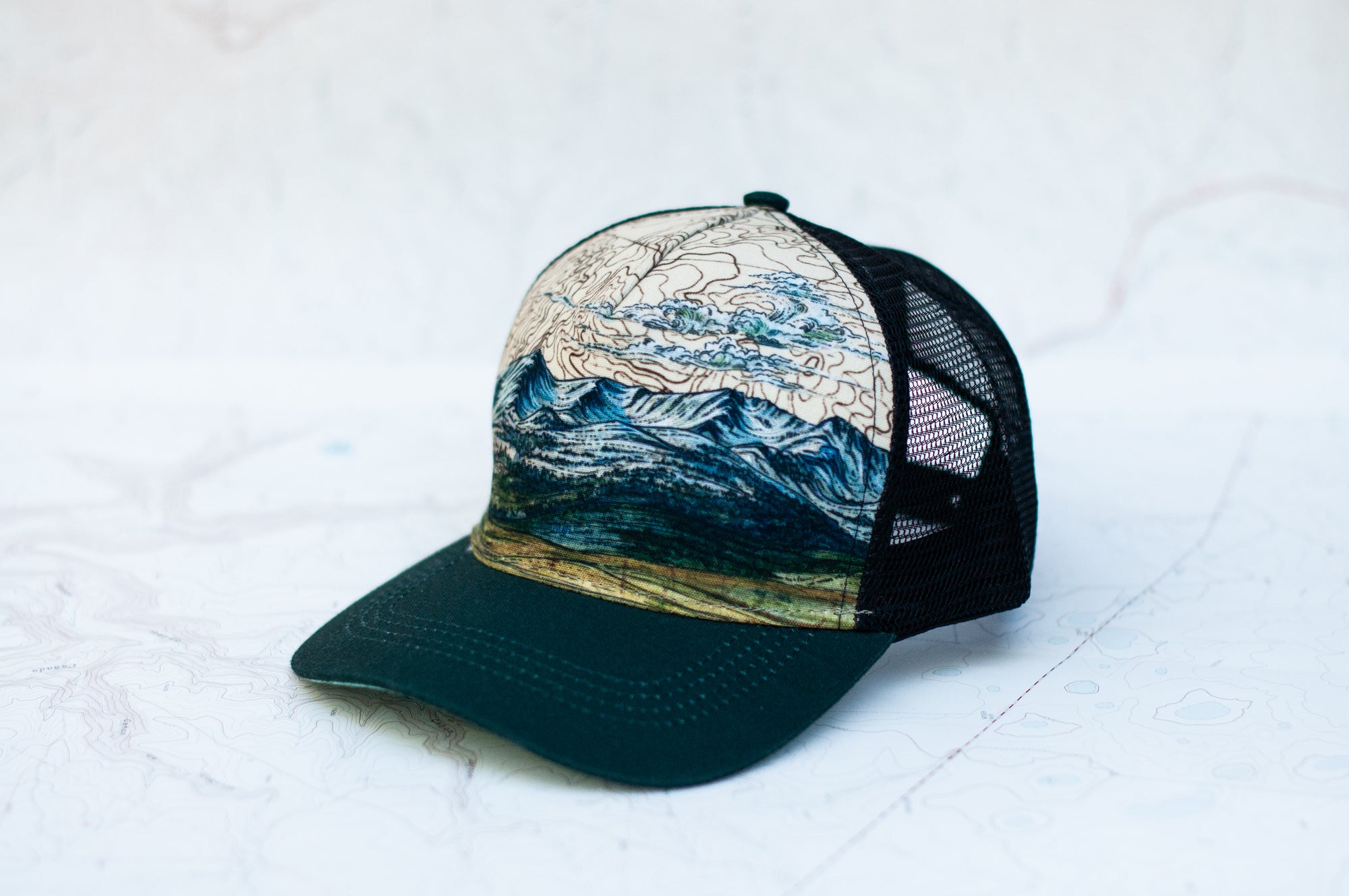 angle view of the final switchback trucker hat featuring artist Katie Jeanne Reim's Bridger print