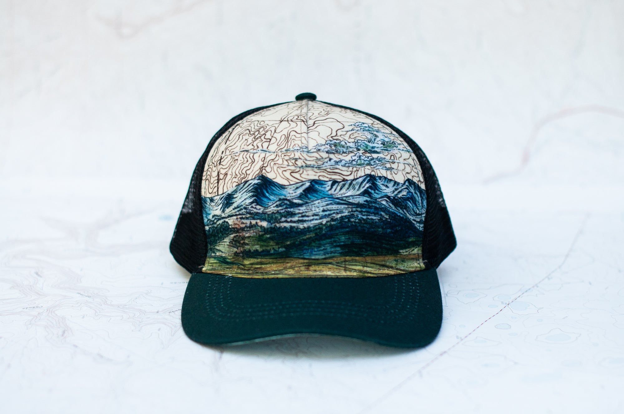 front view of the final switchback trucker hat featuring artist Katie Jeanne Reim&#39;s Bridger print