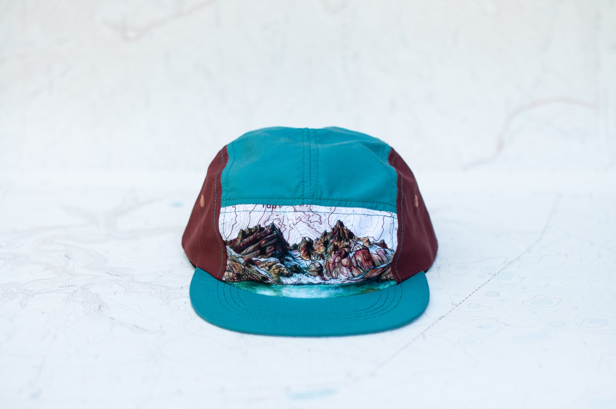 front view of the final switchback 5-panel trail hat featuring artist Katie Jeanne Reim's broken top print