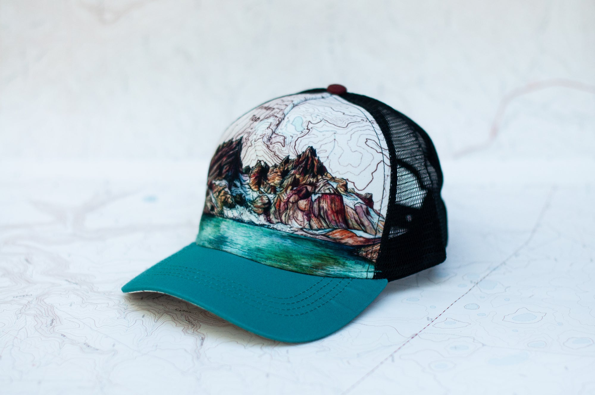angle view of the final switchback trucker hat featuring artist Katie Jeanne Reim's Broken Top print