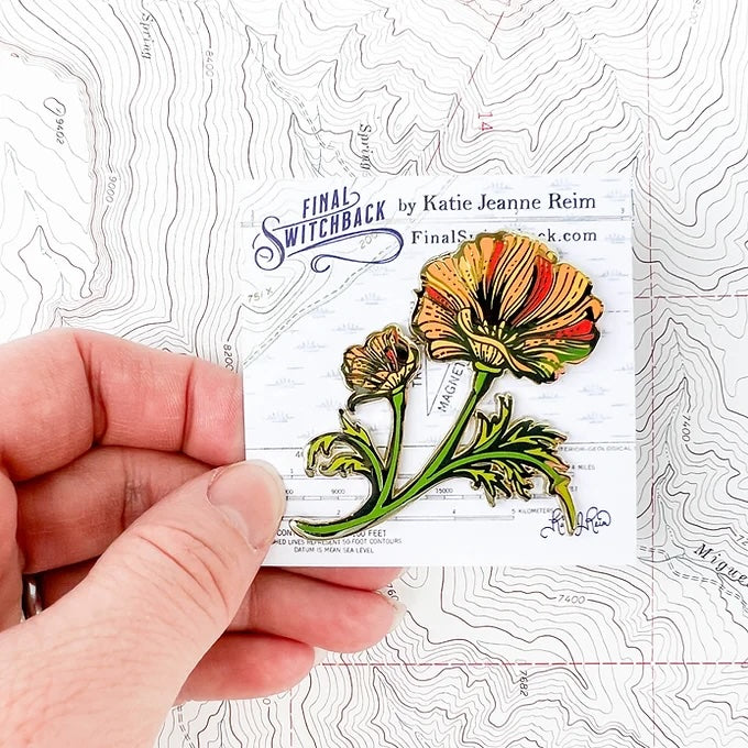 final switchback poppy enamel pin on holder created by artist Katie Jeanne Reim