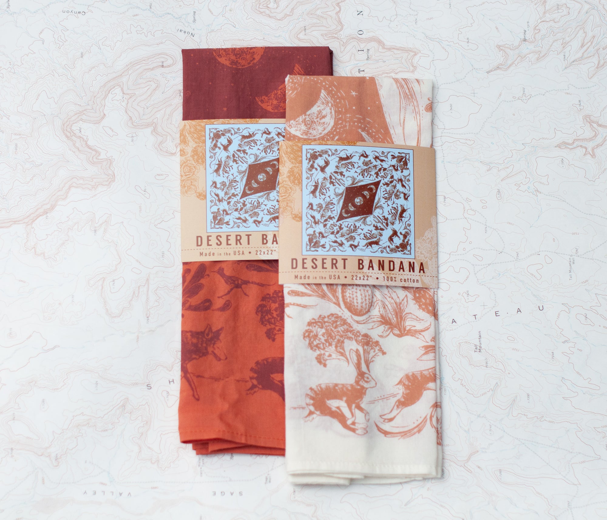 two final switchback cotton bandanas in Desert Nights cream and orange featuring artist Katie Jeanne Reim&#39;s prints