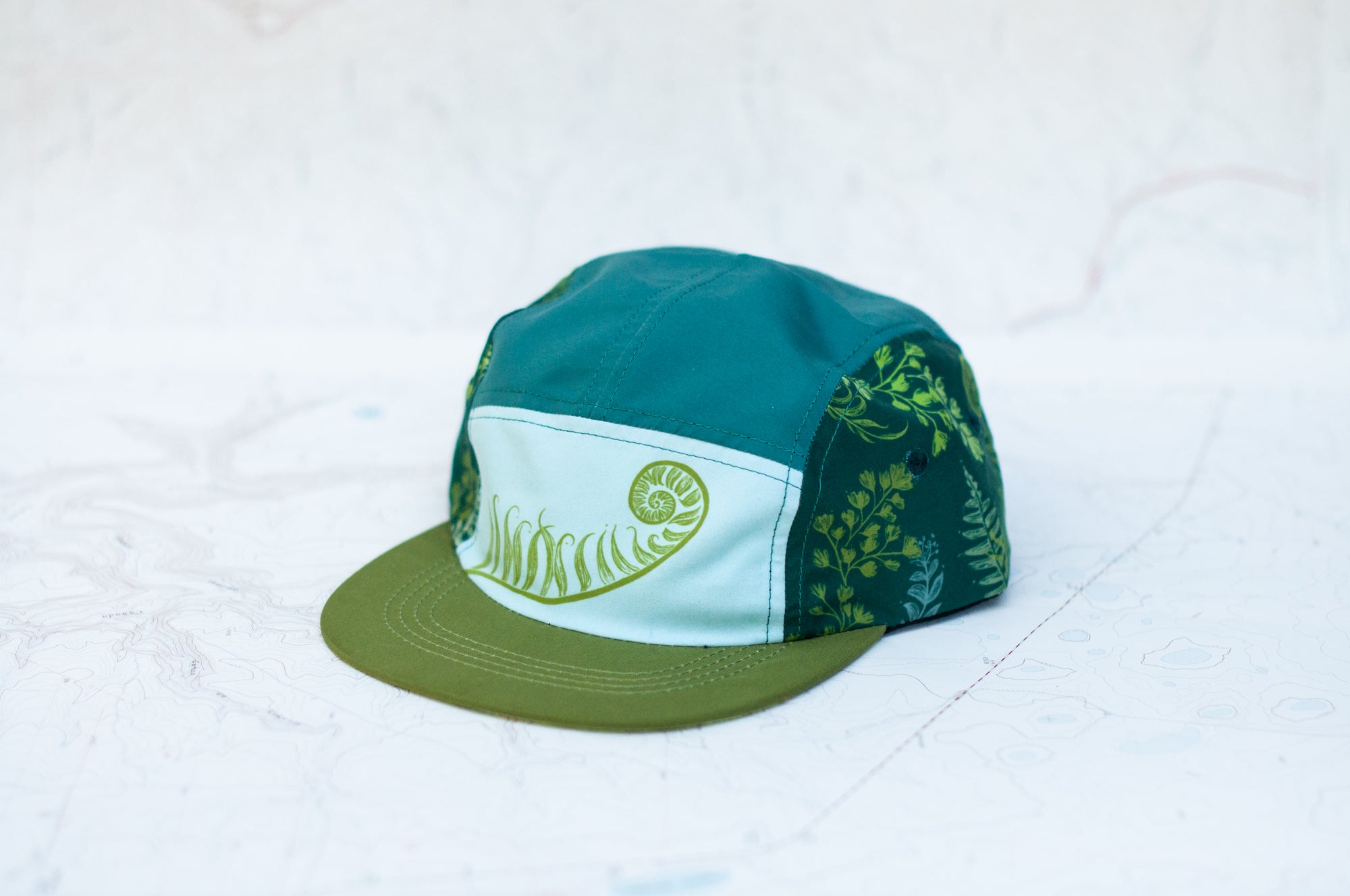 angle view of the final switchback 5-panel trail hat featuring artist Katie Jeanne Reim's Fern print