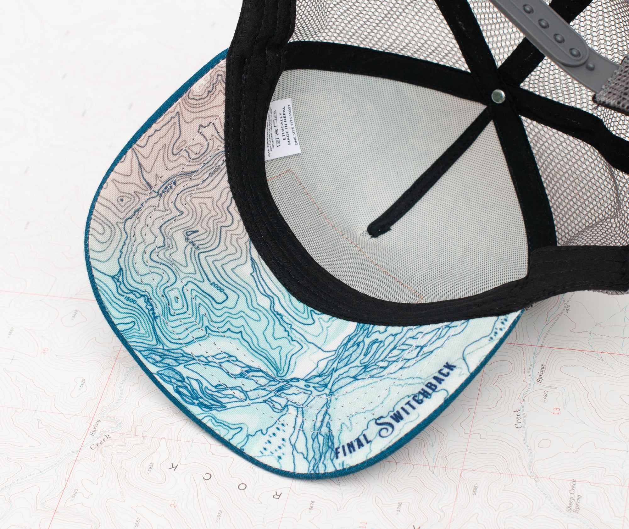 brim view of the final switchback trucker hat featuring artist Katie Jeanne Reim&#39;s Glacier Goat Summit print