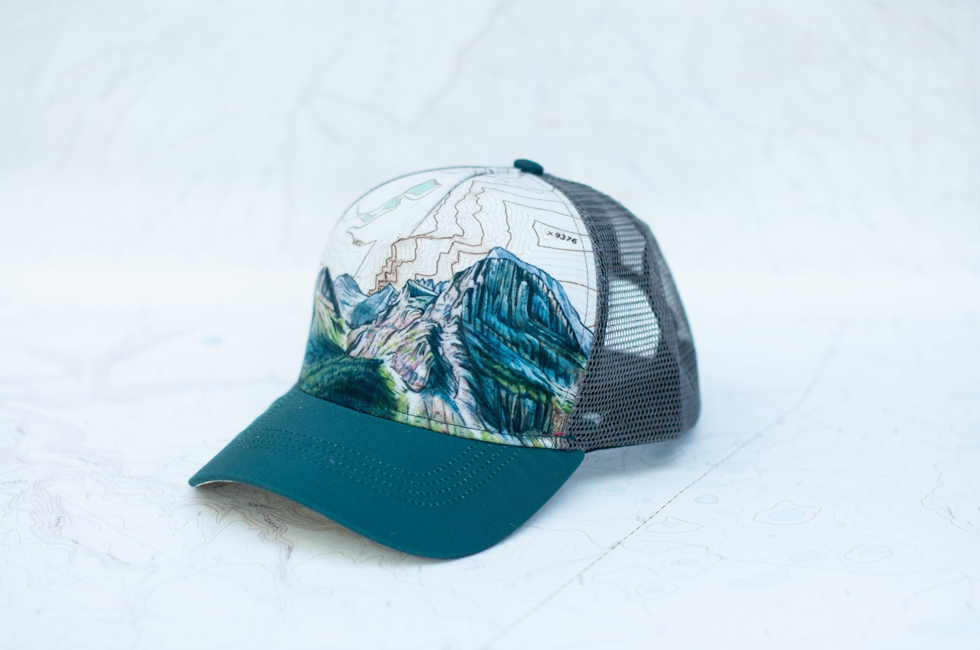 angle view of the final switchback trucker hat featuring artist Katie Jeanne Reim's Glacier Grinnell print