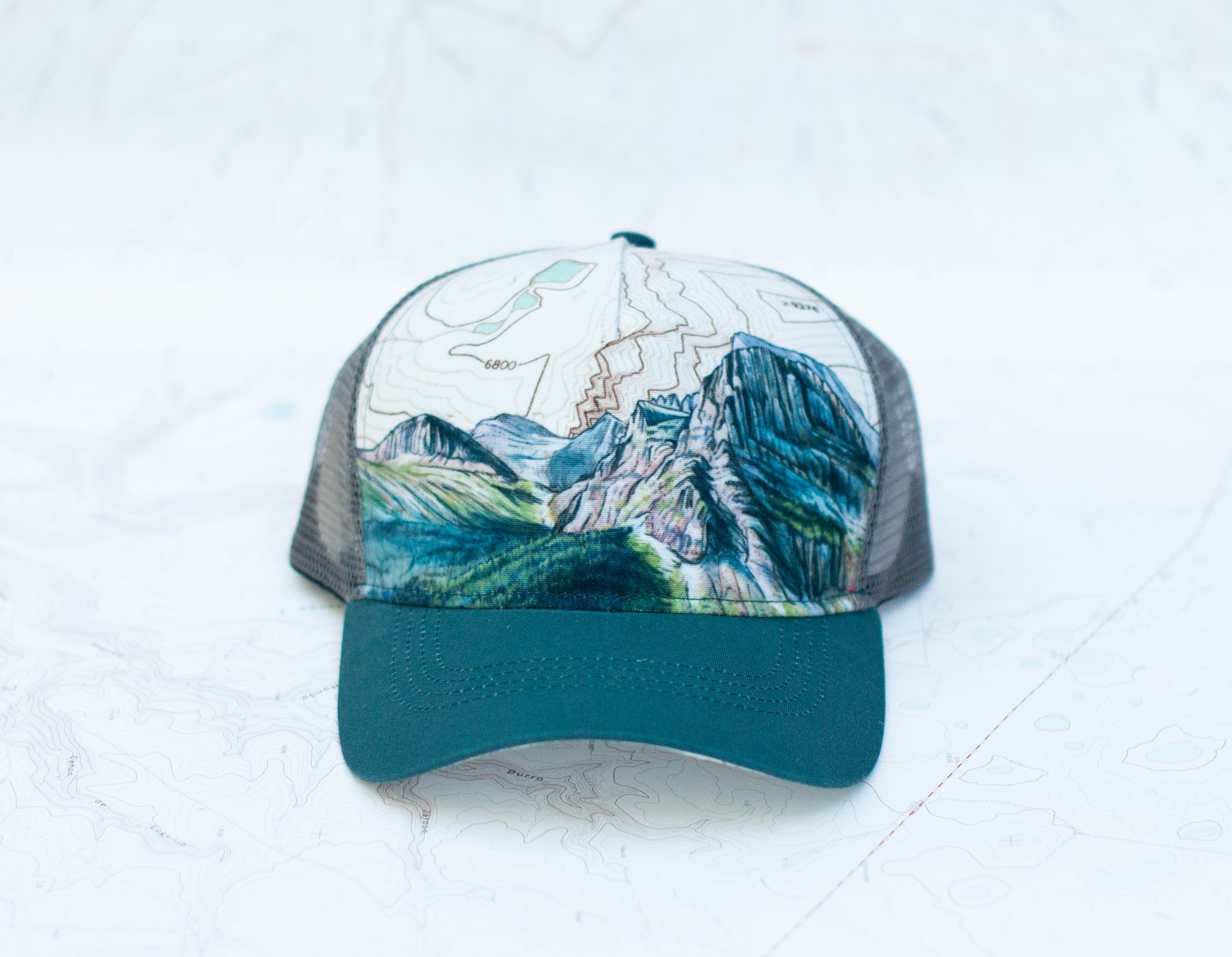 front view of the final switchback trucker hat featuring artist Katie Jeanne Reim&#39;s Glacier Grinnell print
