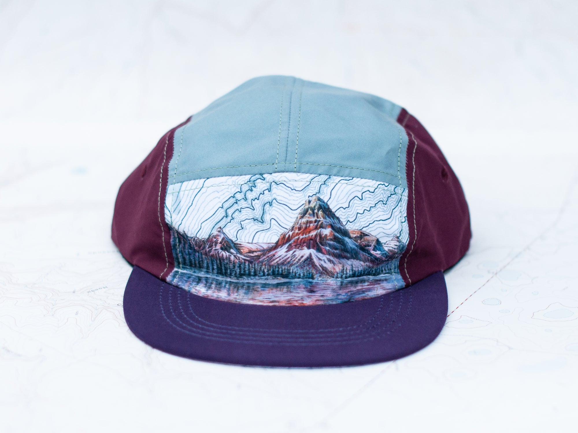 front view of the final switchback 5-panel trail hat featuring artist Katie Jeanne Reim&#39;s Glacier Two Medicine print