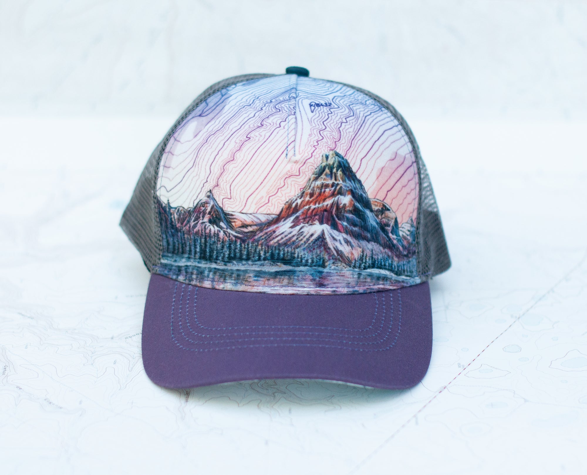 front view of the final switchback trucker hat featuring artist Katie Jeanne Reim&#39;s Glacier Two Medicine print