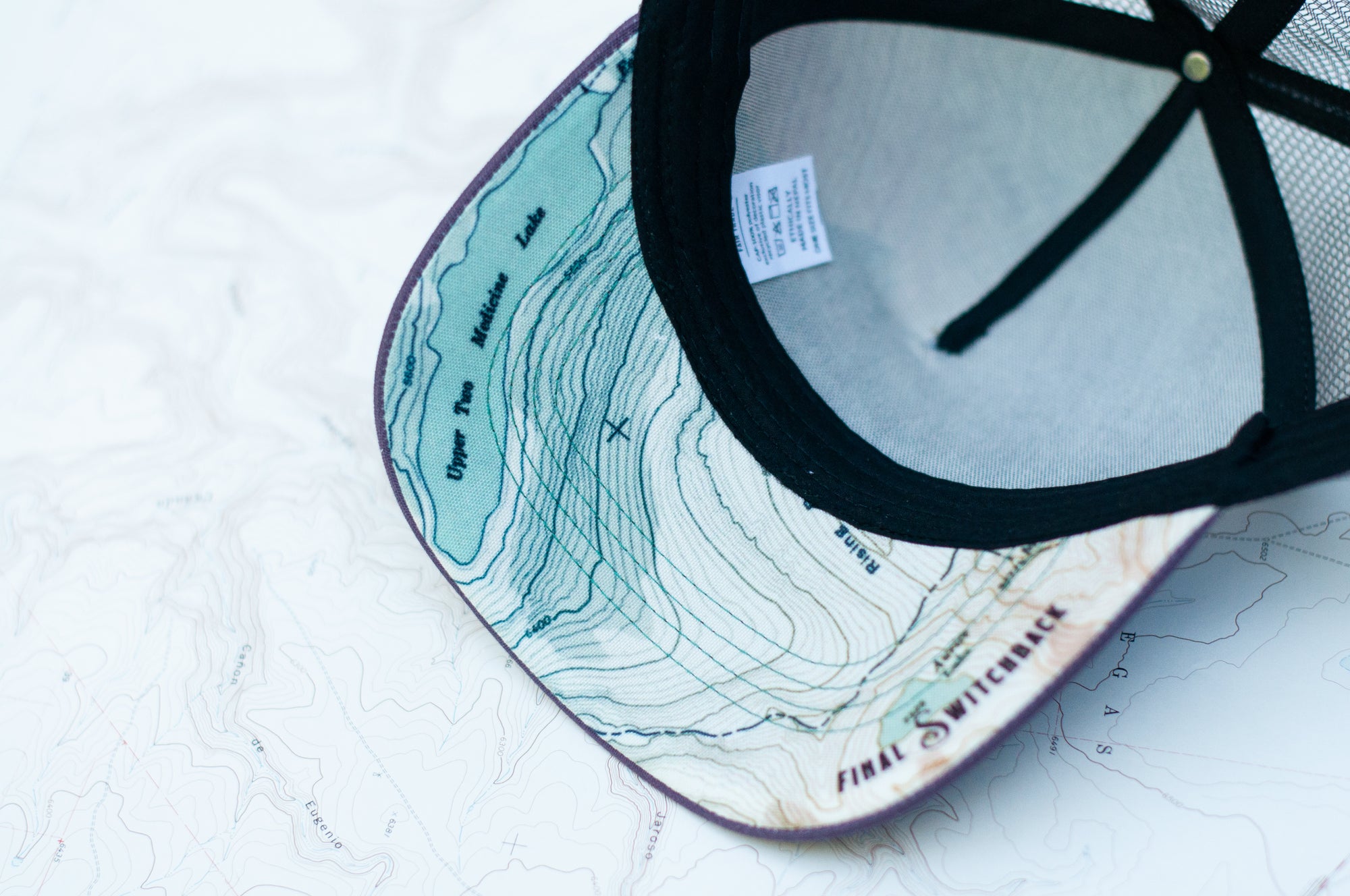 brim view of the final switchback trucker hat featuring artist Katie Jeanne Reim&#39;s Glacier Two Medicine print