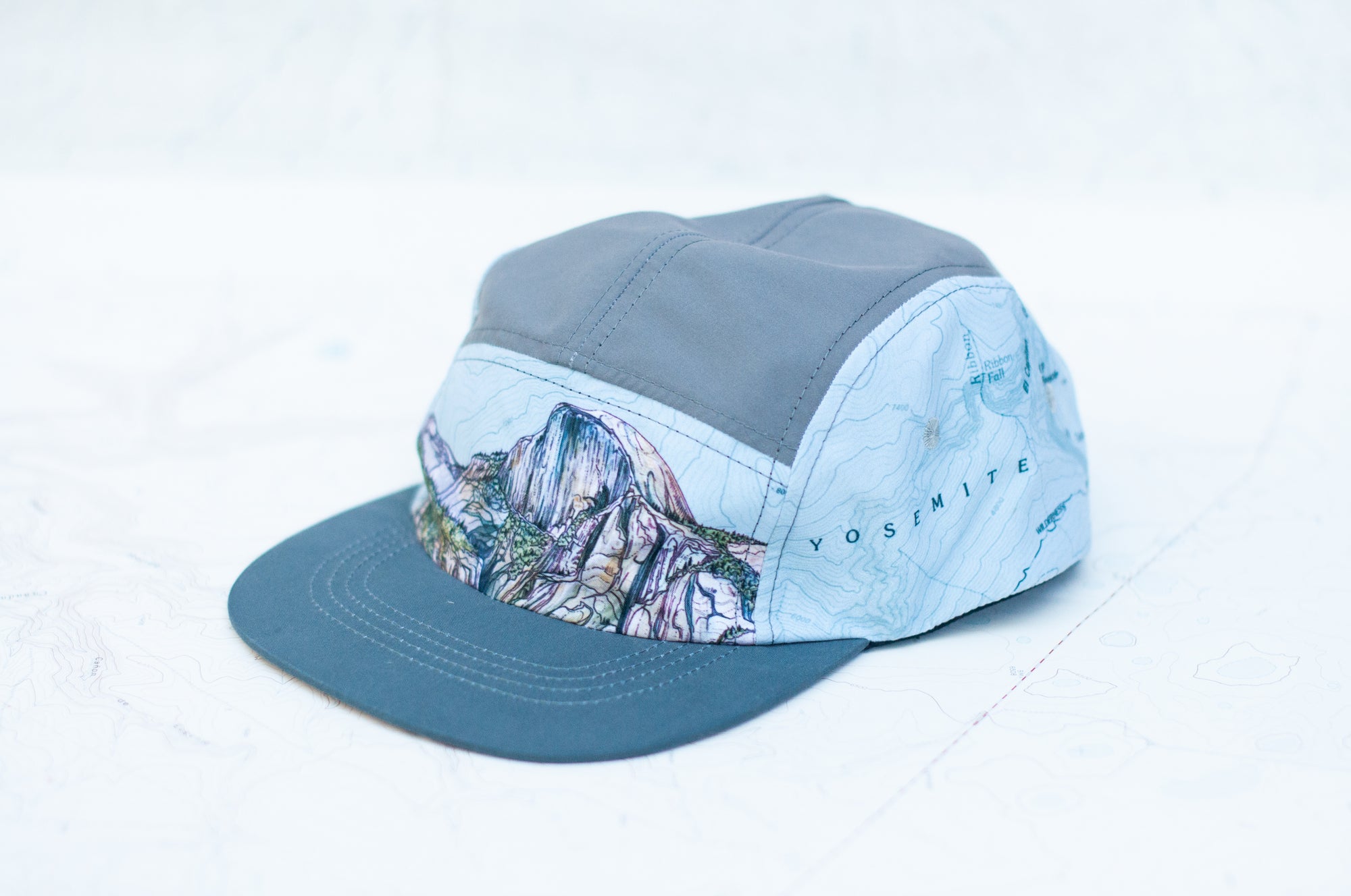 angle view of the final switchback 5-panel trail hat featuring artist Katie Jeanne Reim's half-dome print