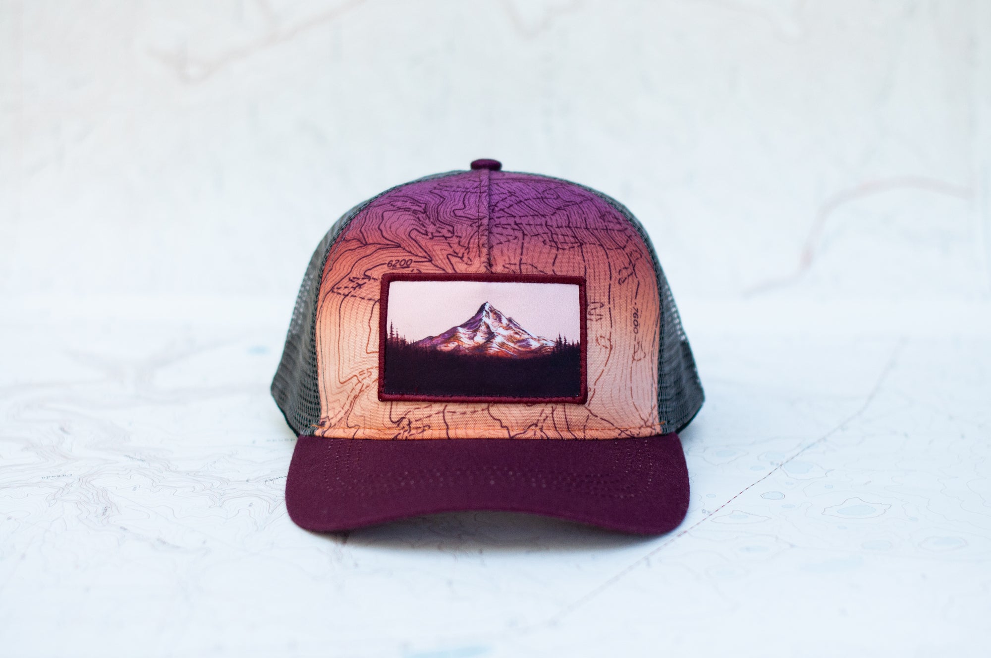 Front view of the final switchback youth trucker hat featuring artist Katie Jeanne Reim's Mount Hood Sunset print