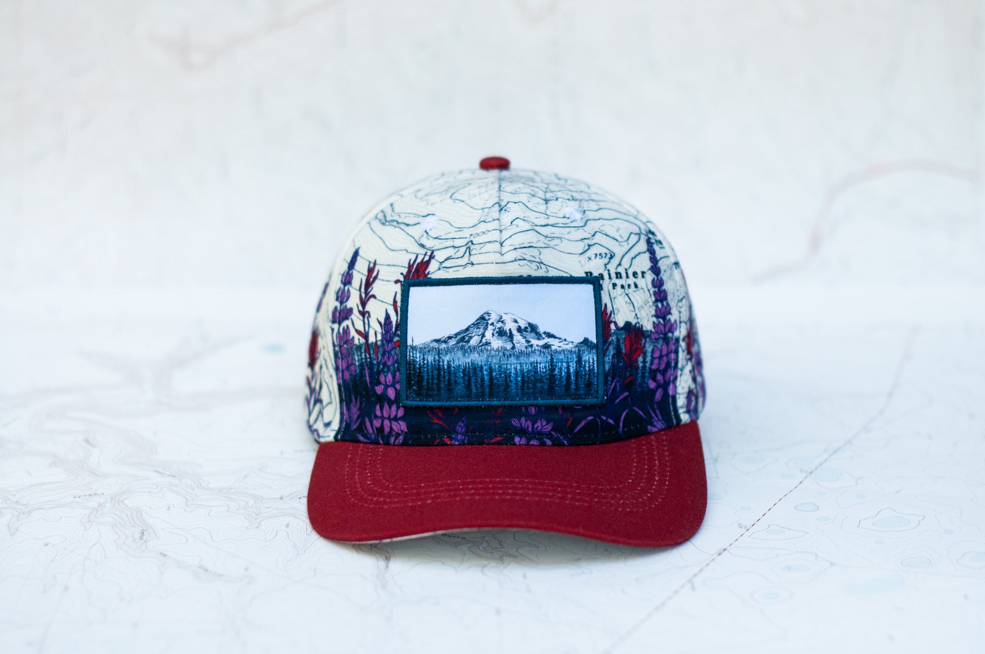 front view of the final switchback twill hat featuring artist Katie Jeanne Reim's Mount Rainier Meadow print