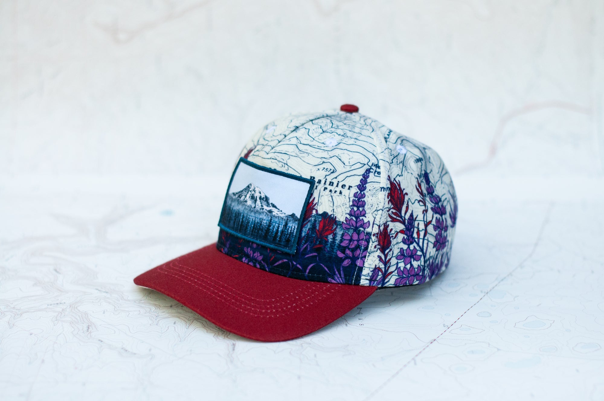 angle view of the final switchback twill hat featuring artist Katie Jeanne Reim's Mount Rainier Meadow print