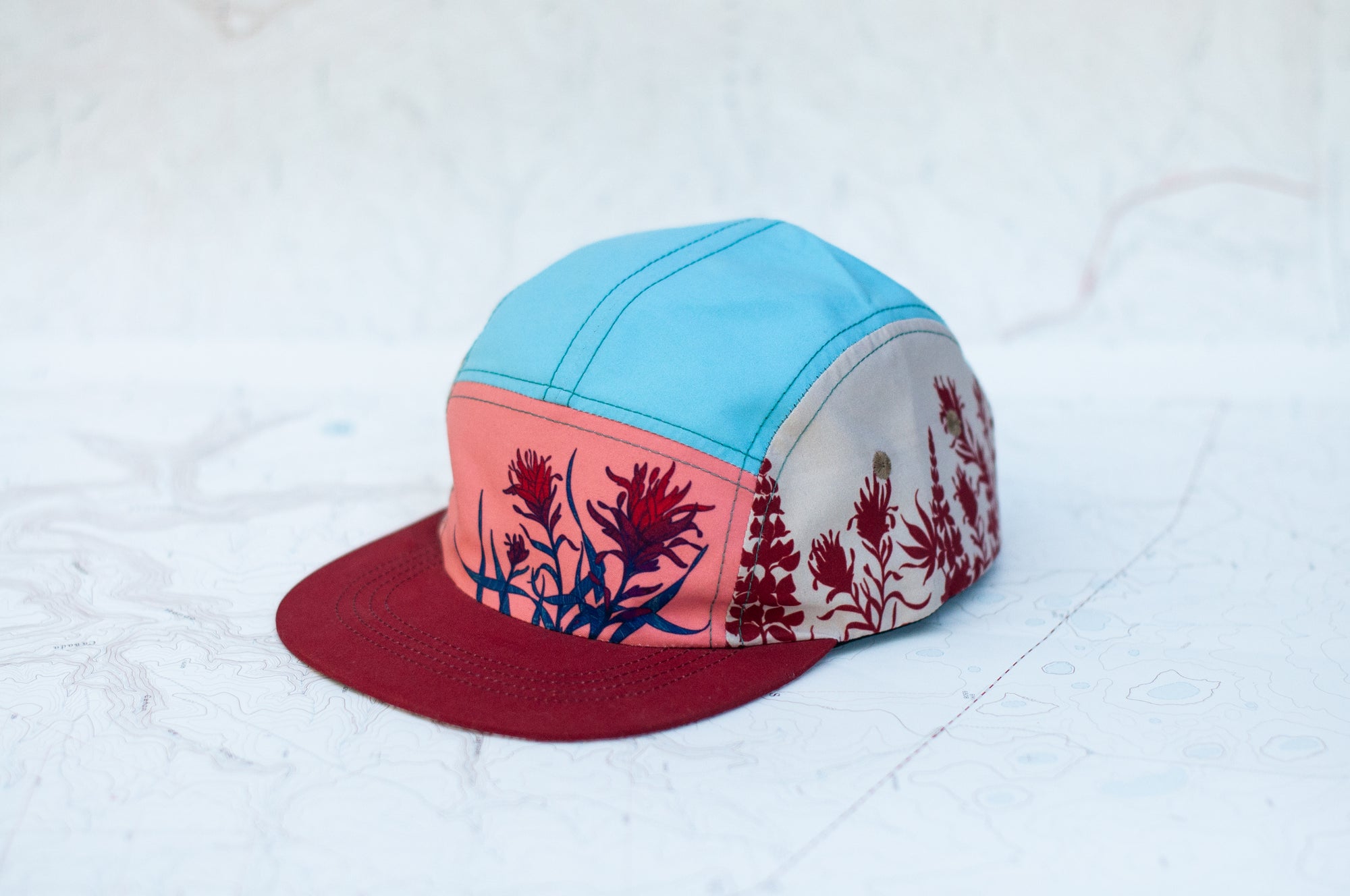 angle view of the final switchback 5-panel trail hat featuring artist Katie Jeanne Reim's Paintbrush print