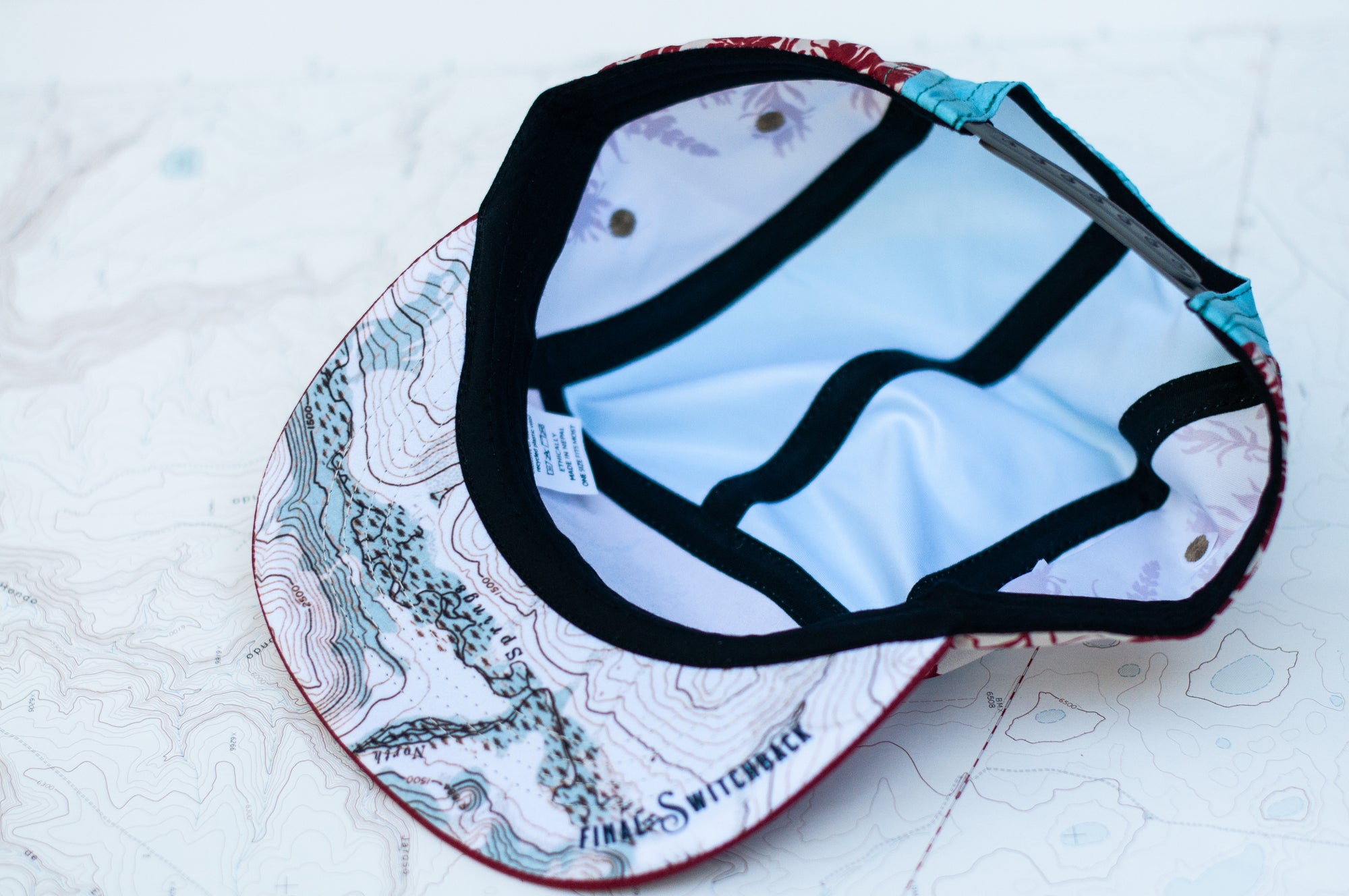 brim view of the final switchback 5-panel trail hat featuring artist Katie Jeanne Reim&#39;s Paintbrush print