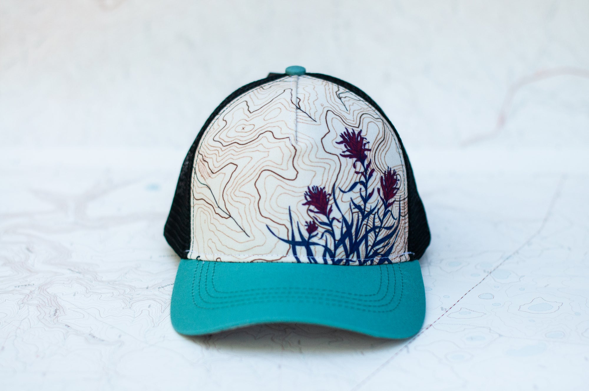 front view of the final switchback trucker hat featuring artist Katie Jeanne Reim&#39;s paintbrush print