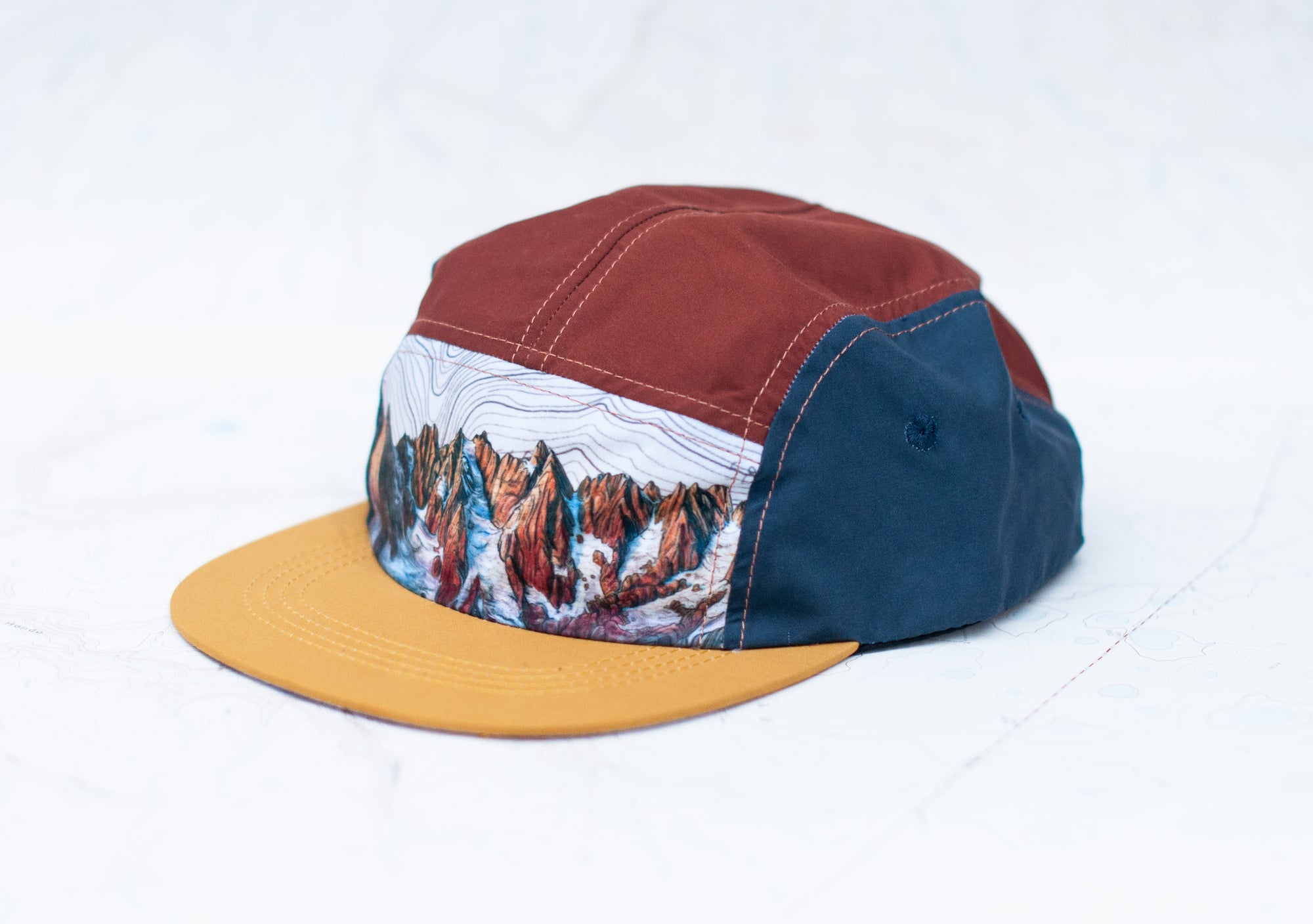 angle view of the final switchback 5-panel trail hat featuring artist Katie Jeanne Reim's Picket Range print