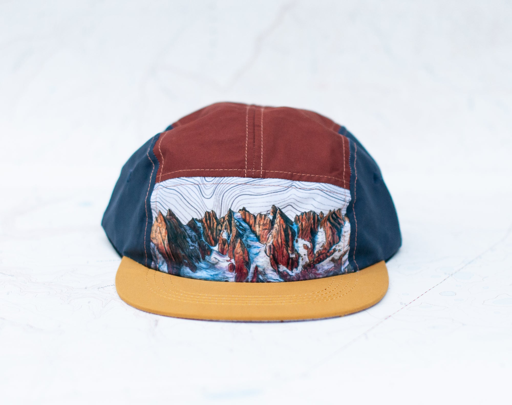 Front view of the final switchback 5-panel trail hat featuring artist Katie Jeanne Reim&#39;s Picket Range print