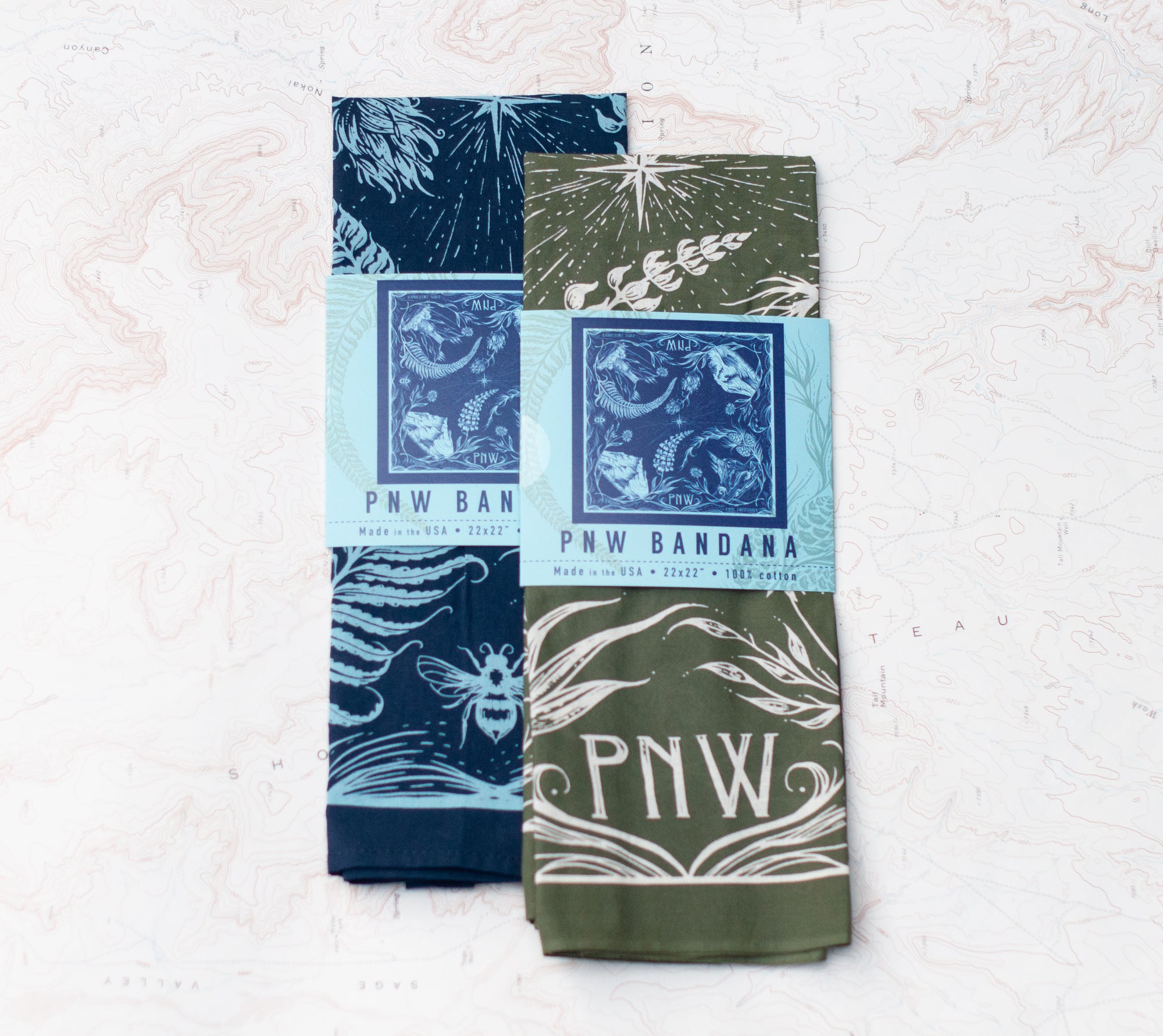 two final switchback cotton bandanas in PNW Green and PNW blue featuring artist Katie Jeanne Reim&#39;s prints