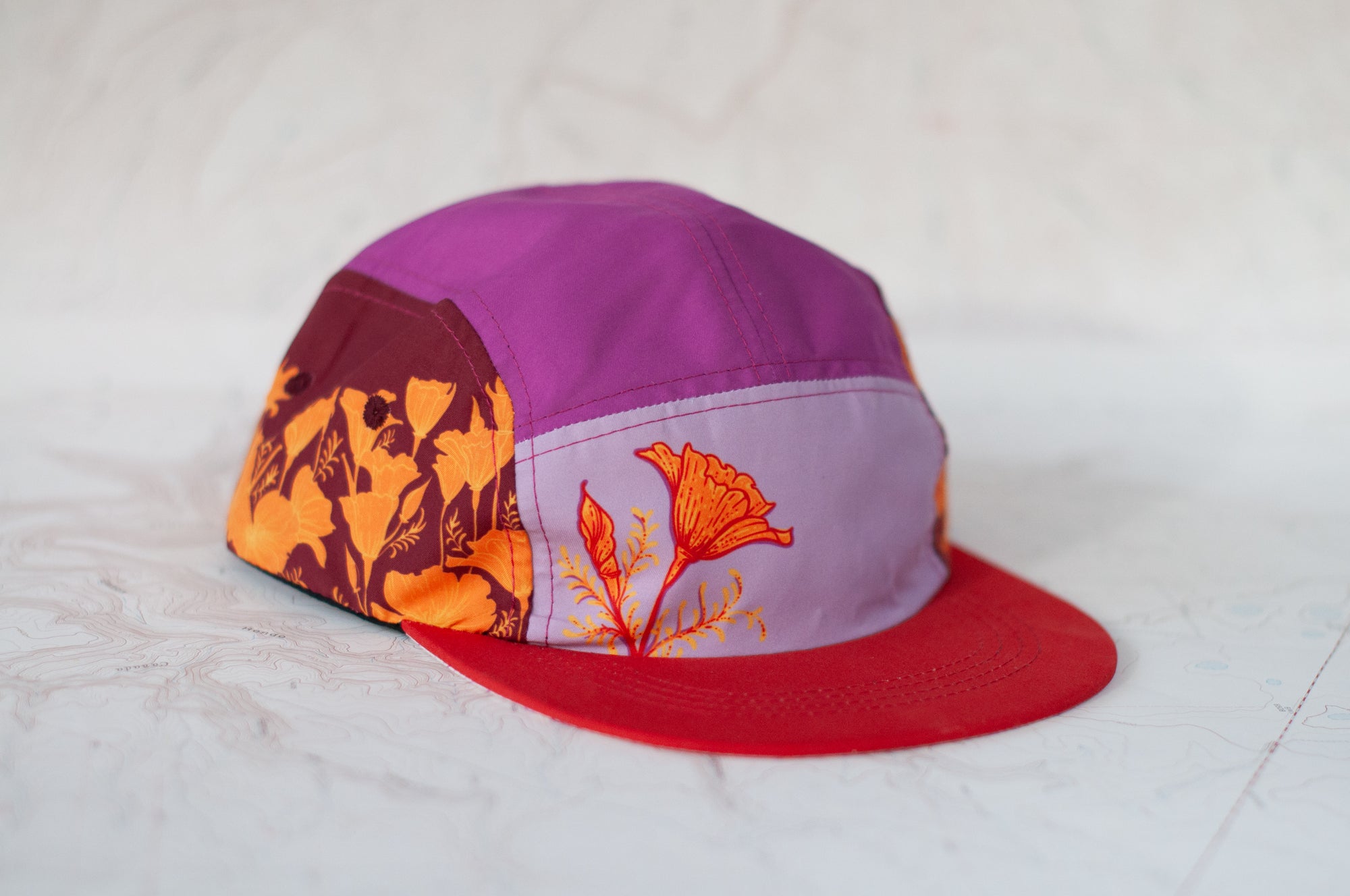 angle view of the final switchback 5-panel trail hat featuring artist Katie Jeanne Reim's Poppy print