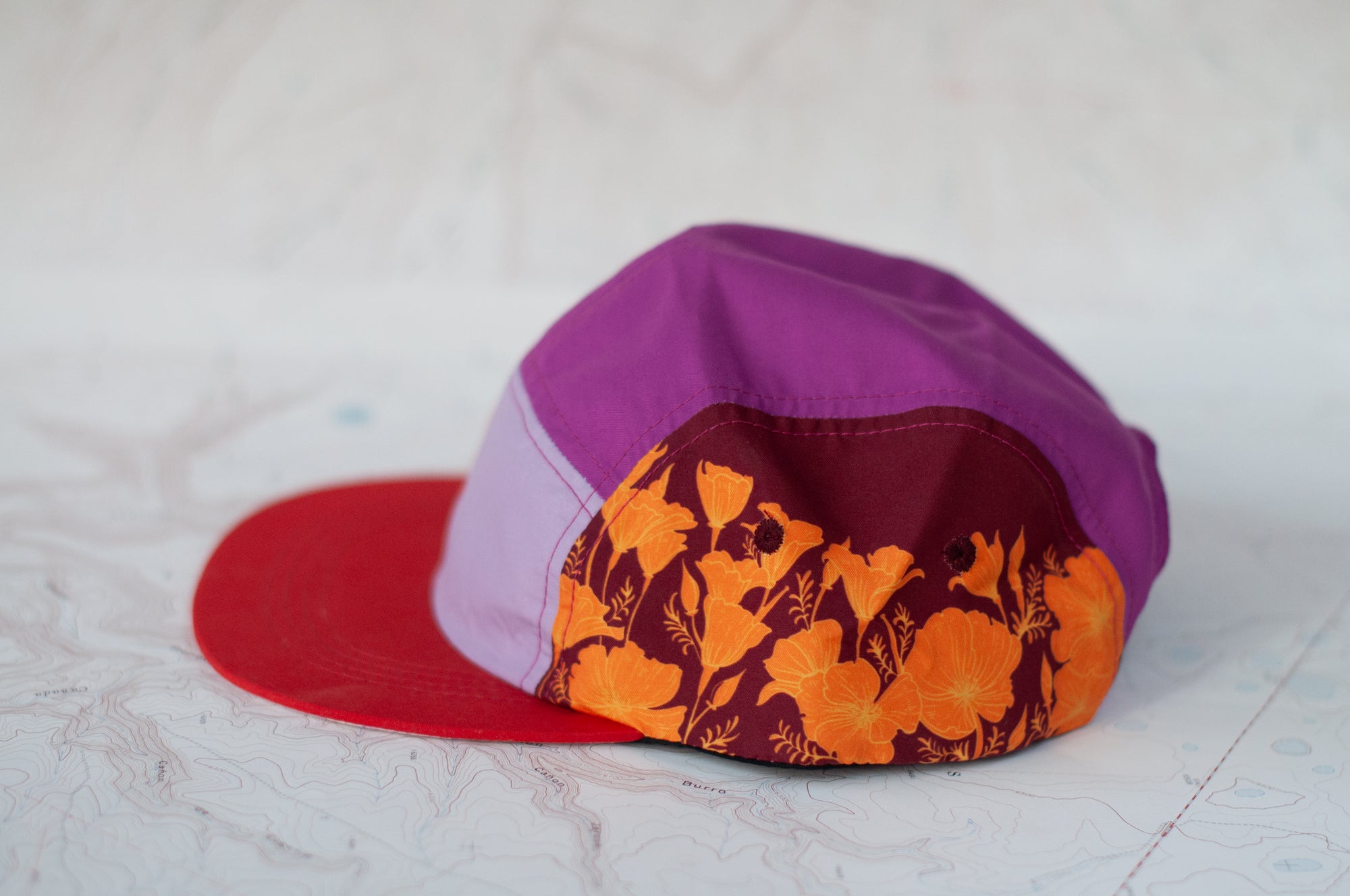 side view of the final switchback 5-panel trail hat featuring artist Katie Jeanne Reim&#39;s Poppy print