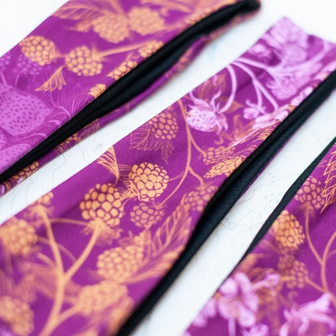 a close-up of final switchback quick dry headband sfeaturing artist Katie Jeanne Reim&#39;s Wildberry print