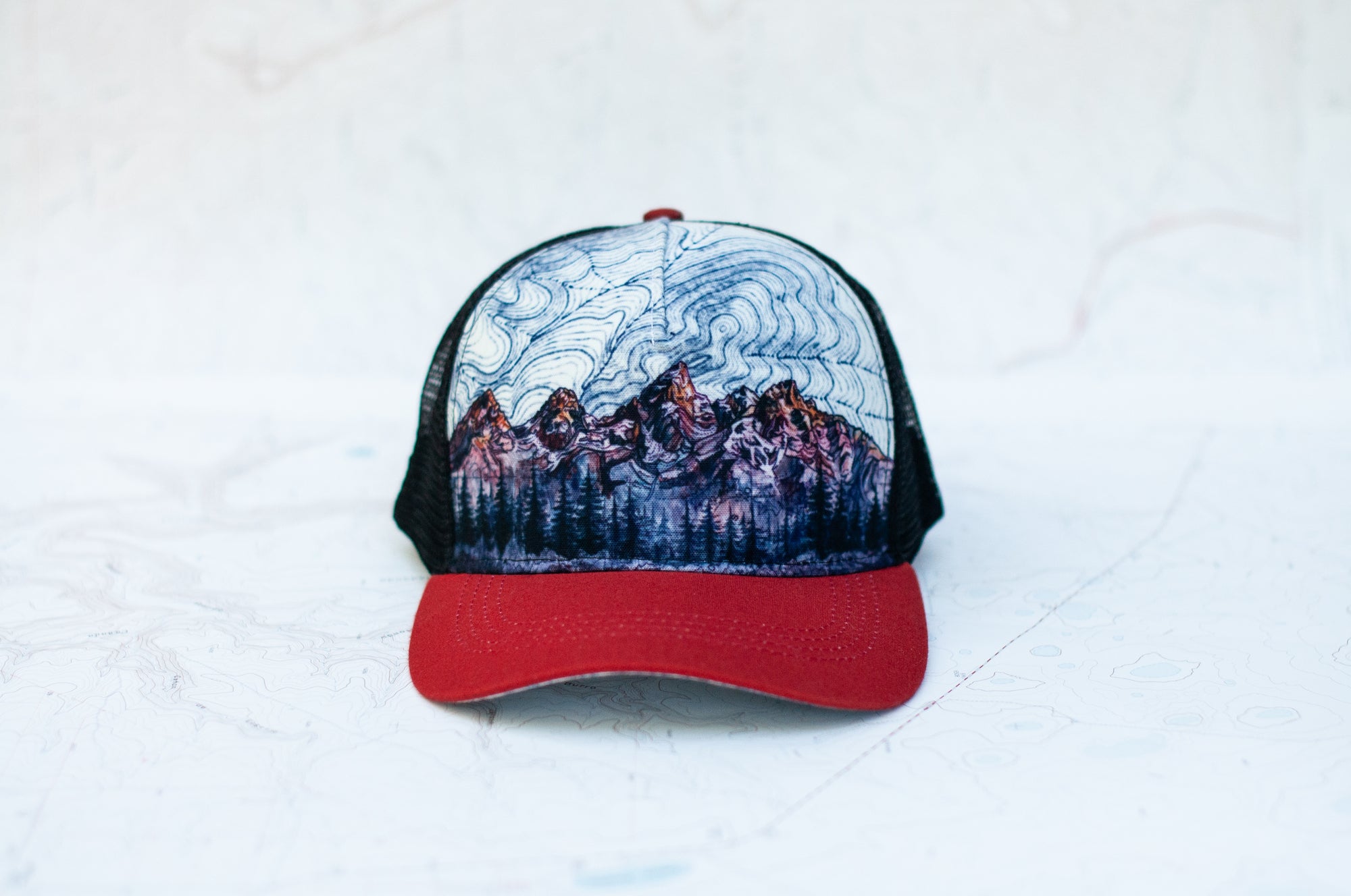 front view of the final switchback trucker hat featuring artist Katie Jeanne Reim&#39;s teton print