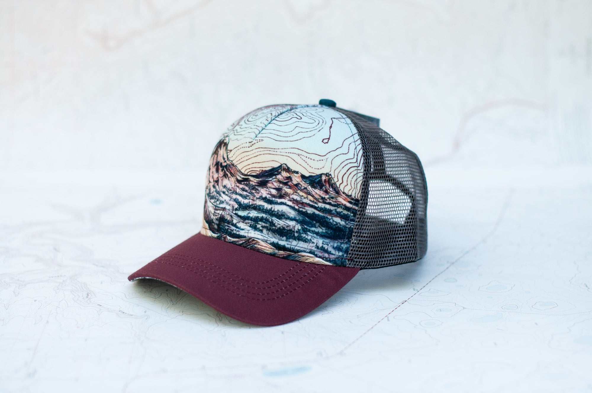 angle view of the final switchback trucker hat featuring artist Katie Jeanne Reim's three sisters print