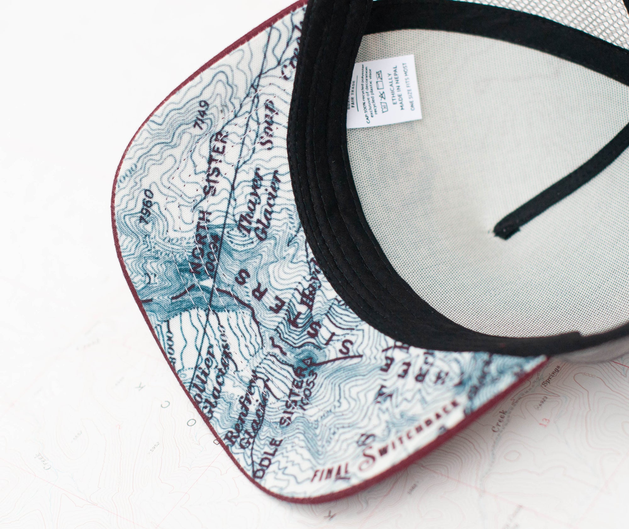brim view of the final switchback trucker hat featuring artist Katie Jeanne Reim&#39;s three sisters print