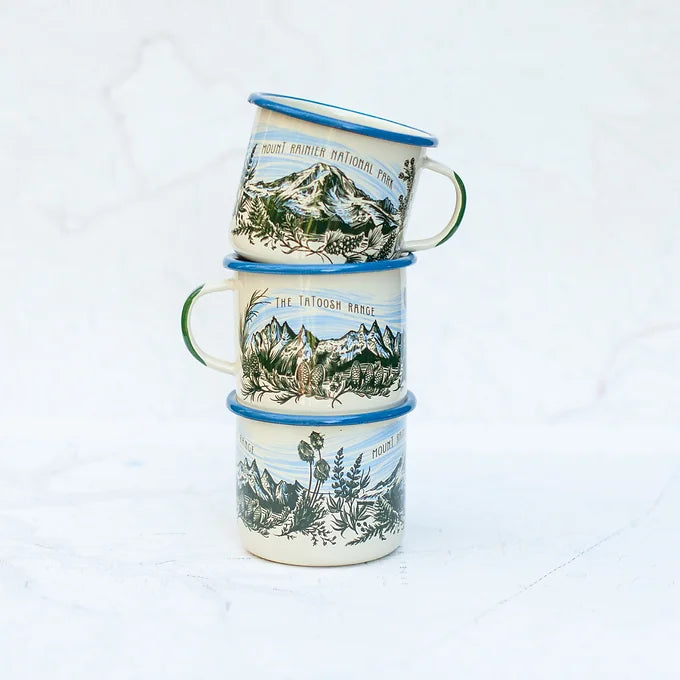Three stacked final switchback fireproof enamel mugs featuring artist Katie Jeanne Reim's Tatoosh Range print