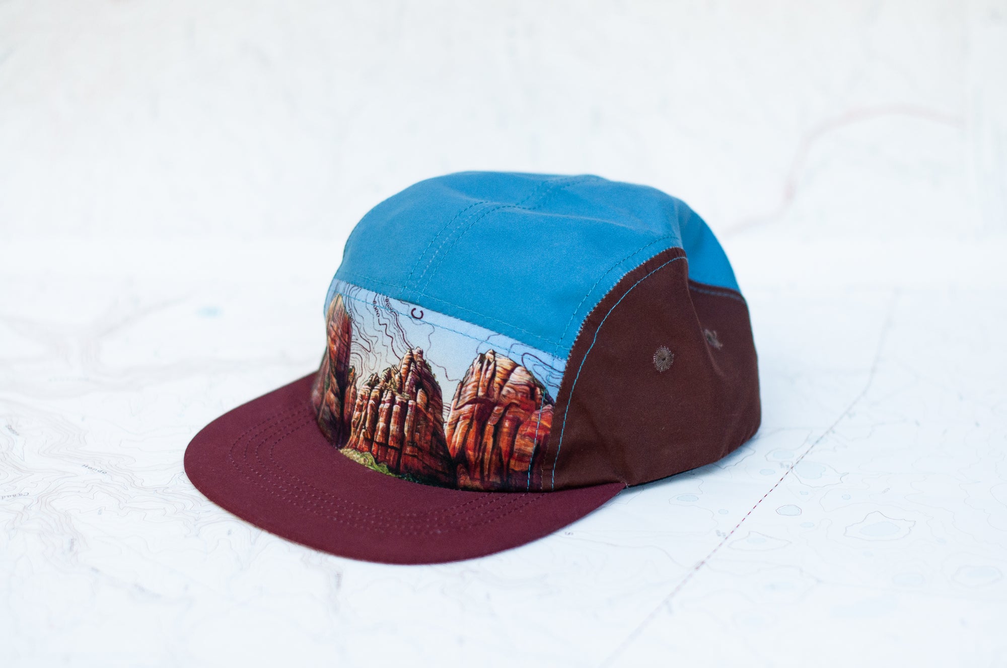 angle view of the final switchback 5-panel trail hat featuring artist Katie Jeanne Reim's Zion print