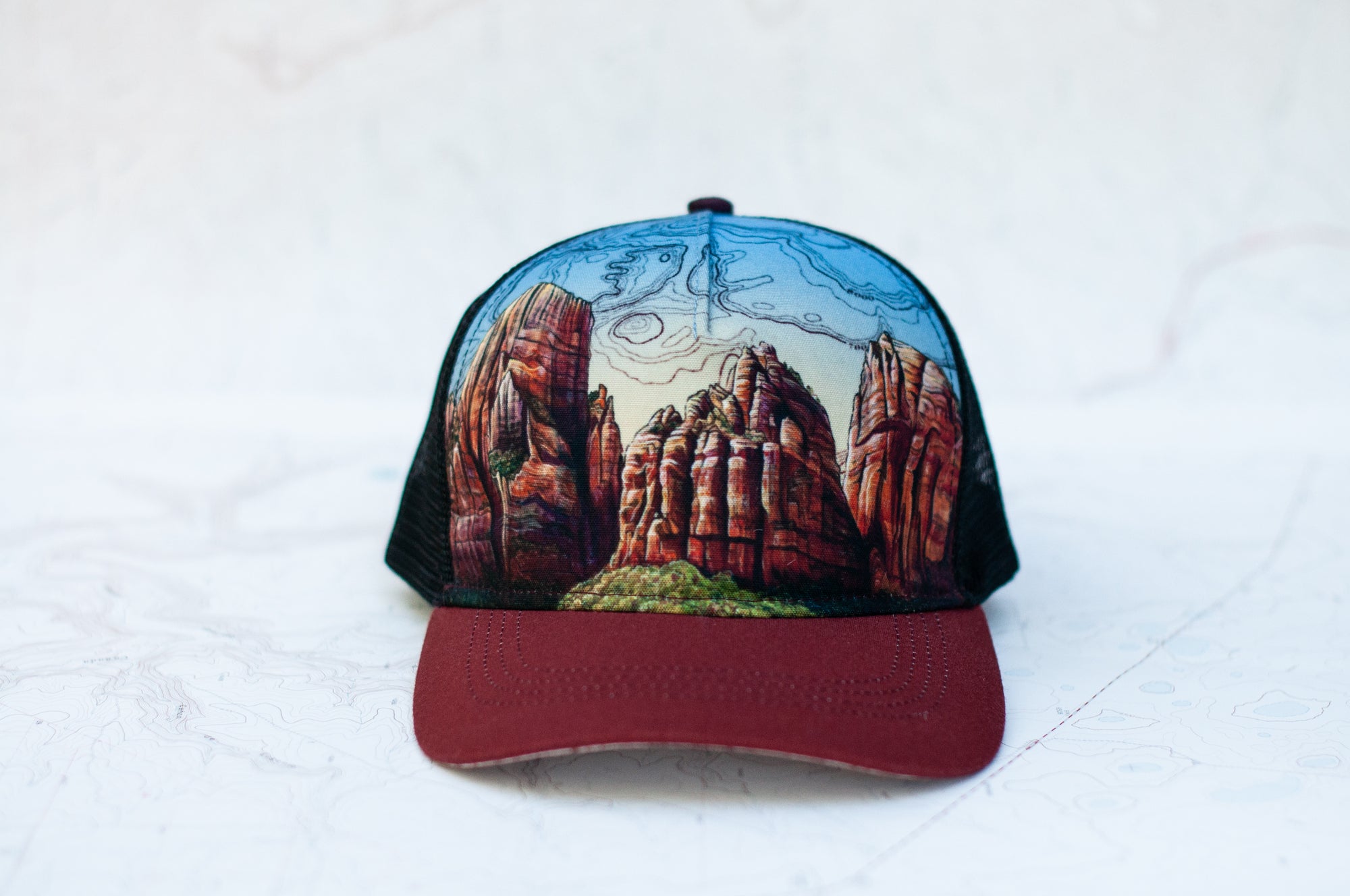 front view of the final switchback trucker hat featuring artist Katie Jeanne Reim&#39;s Zion print