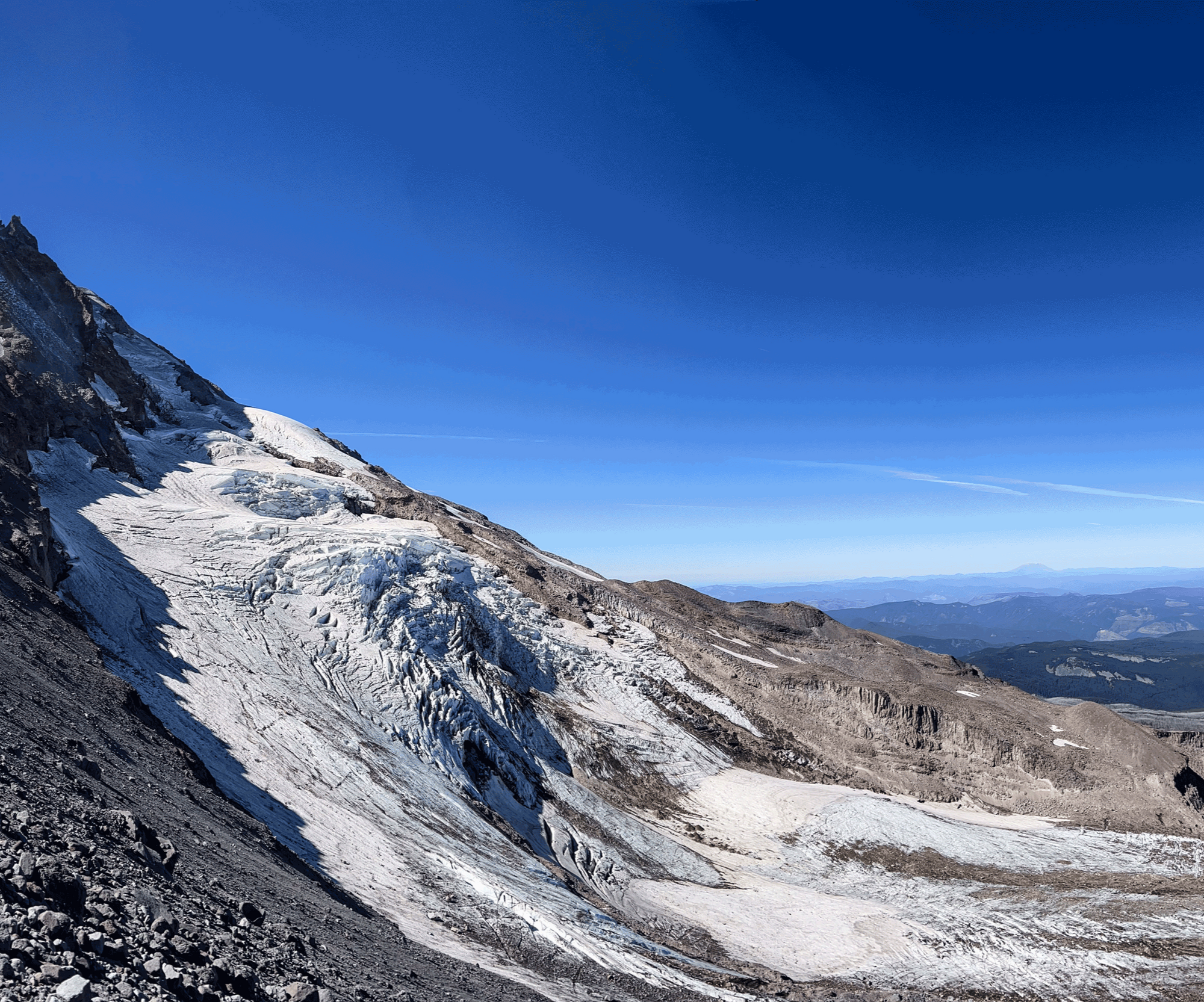 A grey and white mountain peek with a blue sky backdrop